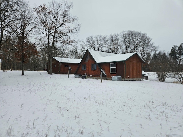 snow covered rear of property with central AC