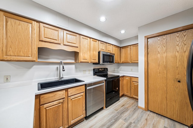 kitchen with stainless steel appliances, light hardwood / wood-style flooring, and sink