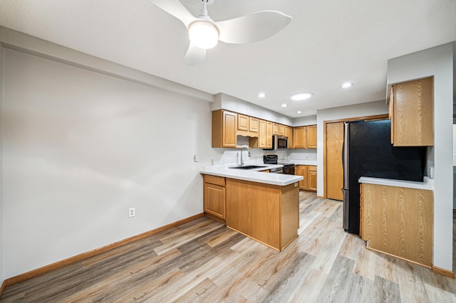 kitchen featuring ceiling fan, sink, stainless steel appliances, light hardwood / wood-style flooring, and kitchen peninsula