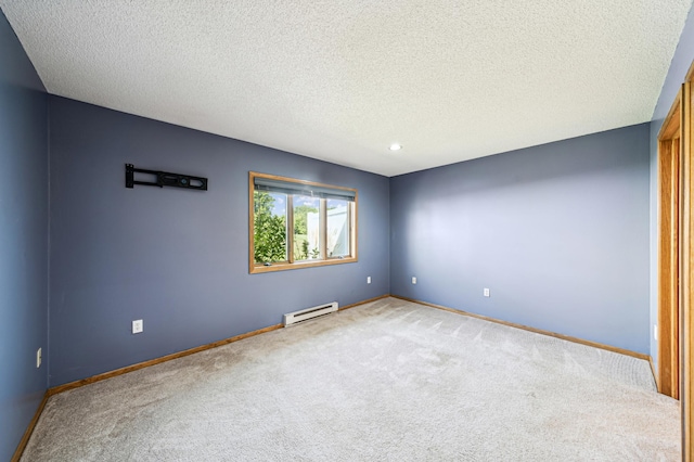 carpeted spare room with a textured ceiling and a baseboard heating unit