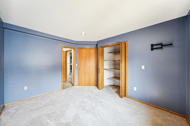 unfurnished bedroom featuring light colored carpet and a closet