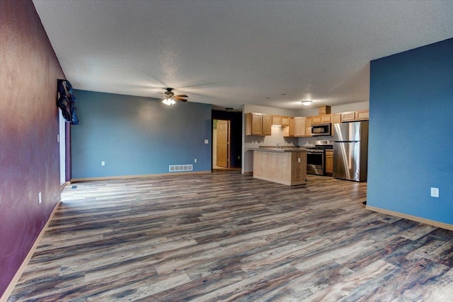 unfurnished living room featuring dark hardwood / wood-style flooring, a textured ceiling, and ceiling fan