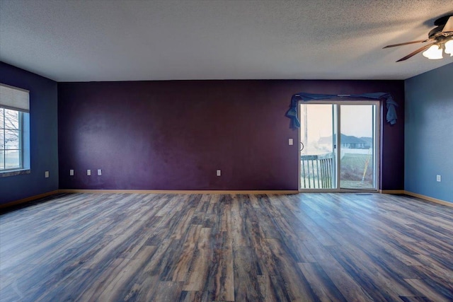 unfurnished room with ceiling fan, dark hardwood / wood-style floors, and a textured ceiling