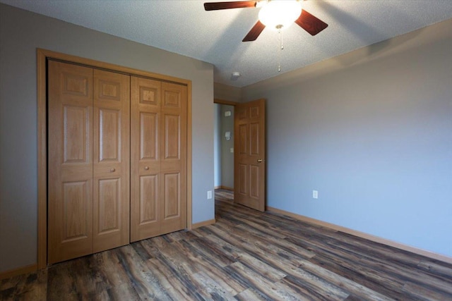 unfurnished bedroom with ceiling fan, dark wood-type flooring, a textured ceiling, and a closet