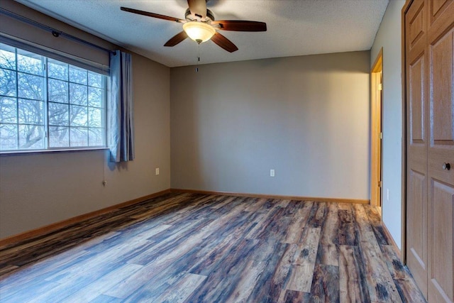 empty room featuring ceiling fan, wood-type flooring, and a textured ceiling