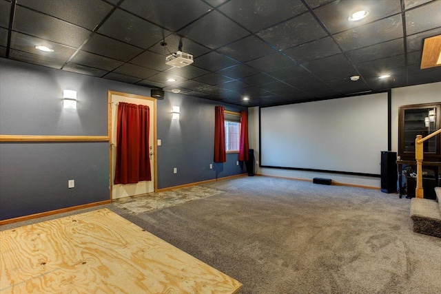 carpeted cinema room with a paneled ceiling