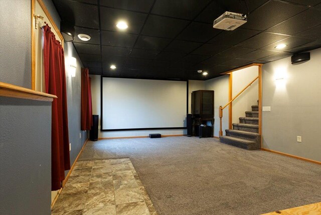 carpeted home theater featuring a drop ceiling