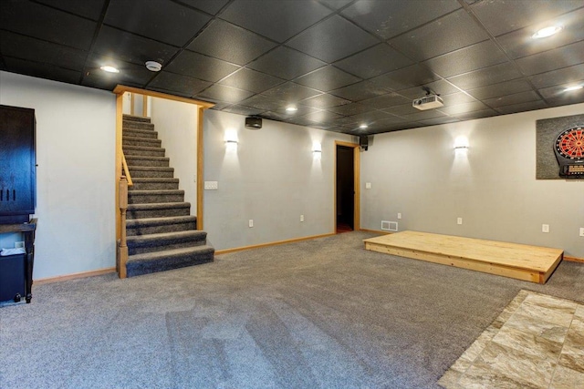 basement with a paneled ceiling and carpet floors