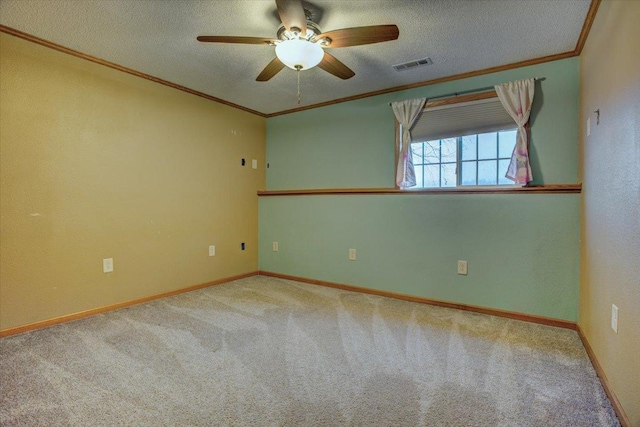 spare room with ceiling fan, ornamental molding, carpet flooring, and a textured ceiling