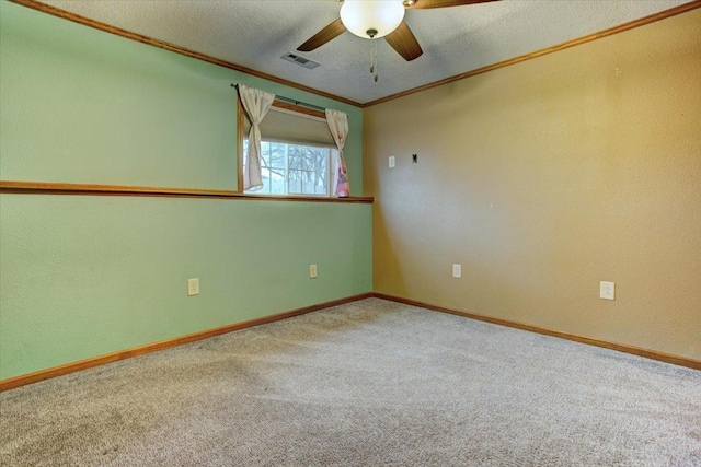 carpeted empty room with ceiling fan, ornamental molding, and a textured ceiling