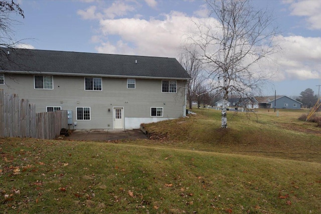 back of property with a yard and a patio area