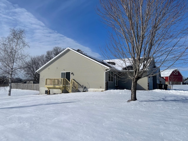 view of snow covered back of property