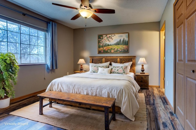 bedroom with ceiling fan, hardwood / wood-style flooring, and a textured ceiling