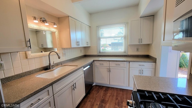 kitchen with dark wood-style floors, stainless steel dishwasher, gas stove, white cabinetry, and a sink