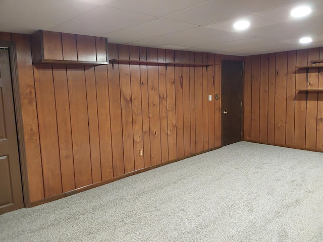 basement featuring wood walls and light colored carpet