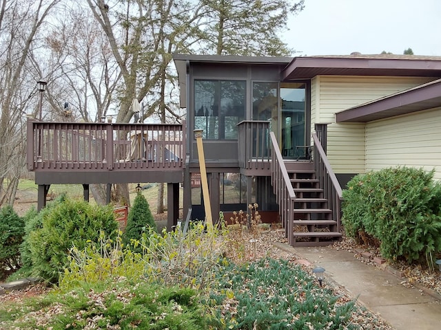 back of house featuring a sunroom and a wooden deck