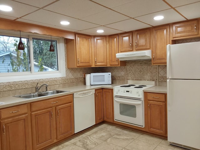 kitchen with pendant lighting, a drop ceiling, white appliances, sink, and tasteful backsplash