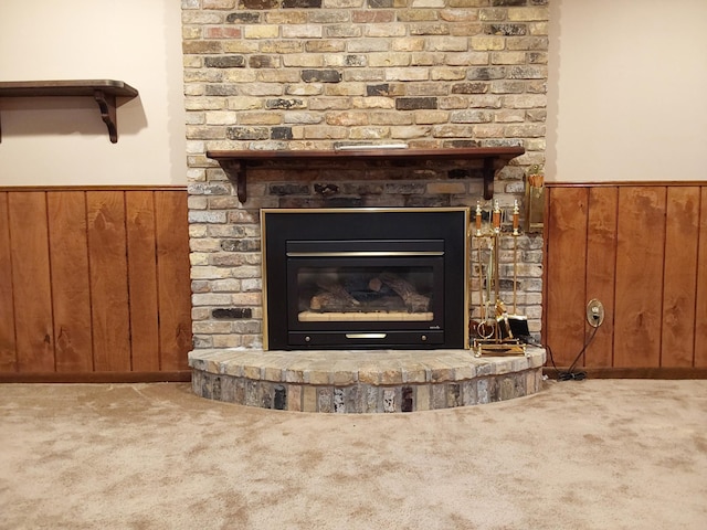 interior details with carpet, a fireplace, and wooden walls