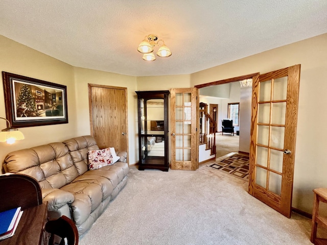 carpeted living room with a textured ceiling and french doors