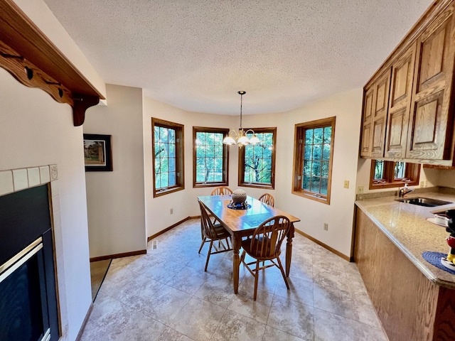 dining space with a textured ceiling, a notable chandelier, and sink