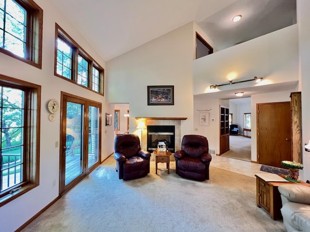 living area with a fireplace, light carpet, and high vaulted ceiling