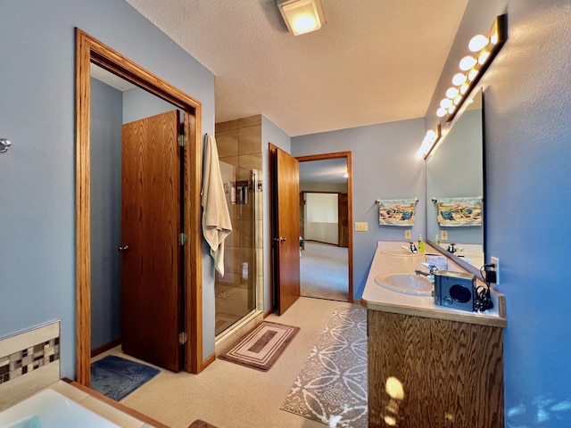 bathroom featuring vanity, a shower with door, and a textured ceiling