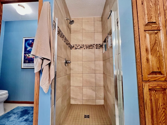 bathroom with toilet, a shower with door, and a textured ceiling