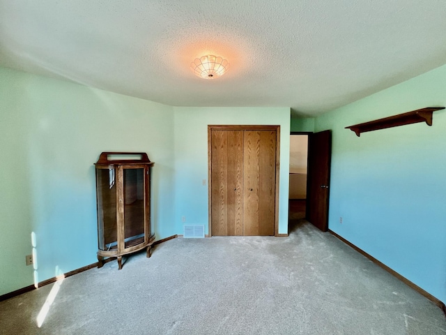 unfurnished bedroom featuring carpet and a textured ceiling