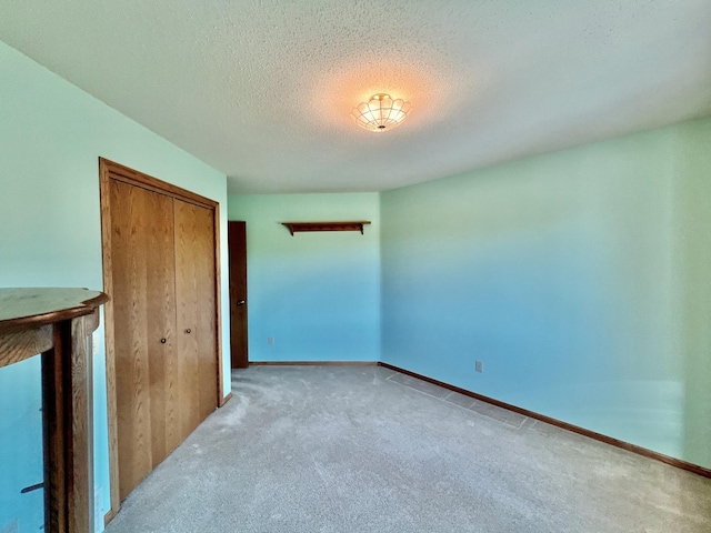 carpeted spare room with a textured ceiling