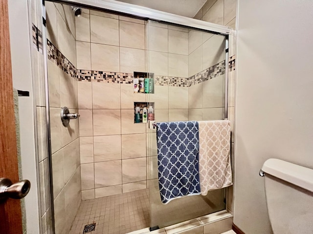 bathroom with an enclosed shower and toilet