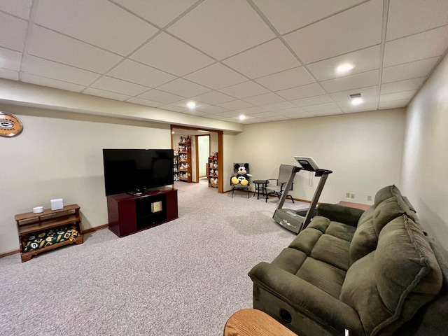 living room featuring carpet and a drop ceiling