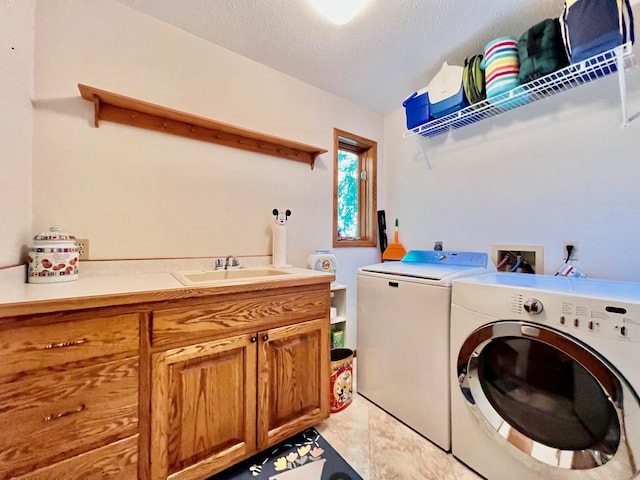 laundry room with cabinets, a textured ceiling, sink, light tile patterned floors, and washing machine and clothes dryer