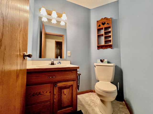 bathroom with tile patterned flooring, vanity, and toilet