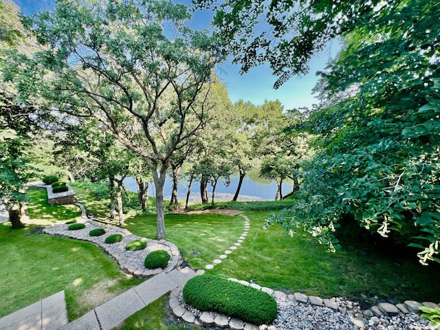 view of home's community featuring a lawn and a water view