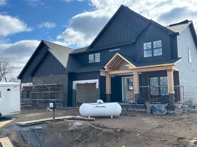 view of front of home with a garage, roof with shingles, and board and batten siding