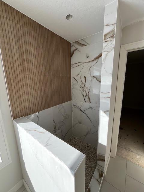 full bathroom with marble finish floor and a marble finish shower