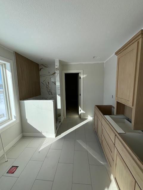 bathroom featuring a textured ceiling, a shower stall, and baseboards