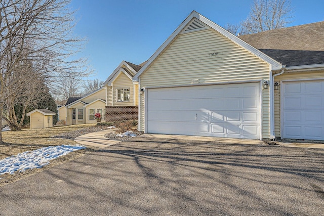 view of front of property featuring a garage and a storage shed