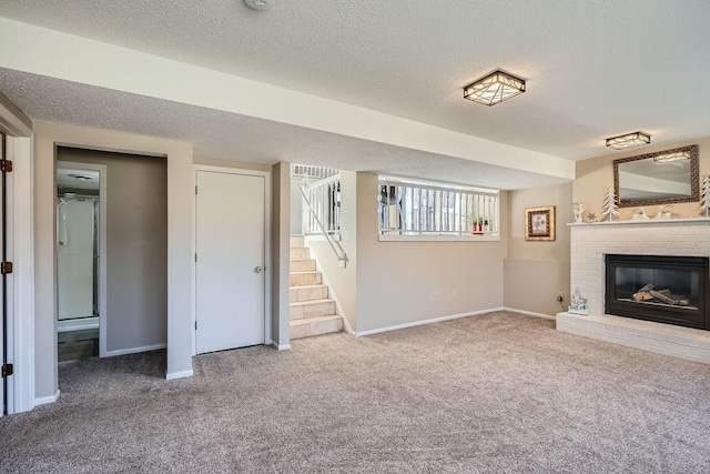 unfurnished living room featuring a textured ceiling, carpet floors, and a fireplace