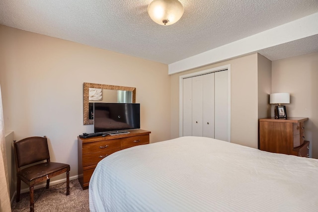 bedroom with carpet flooring, a textured ceiling, and a closet