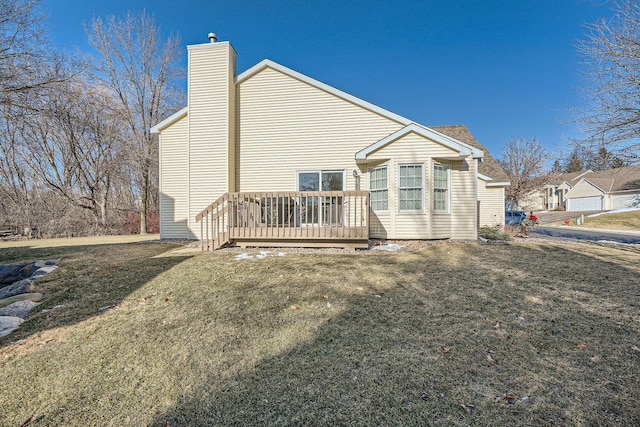 rear view of house featuring a deck and a lawn