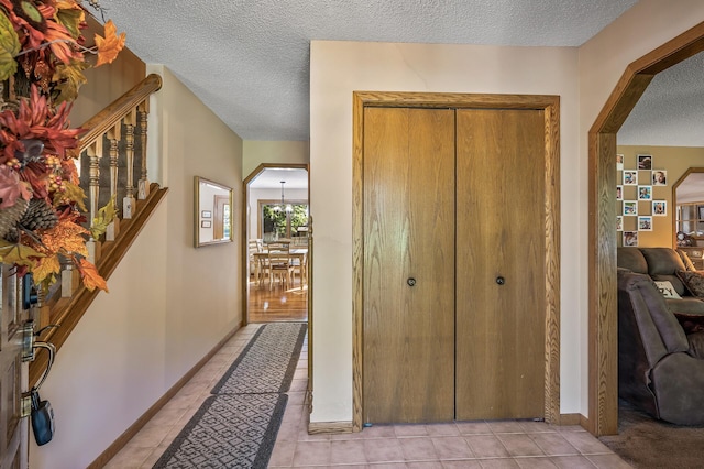 tiled entrance foyer featuring a textured ceiling