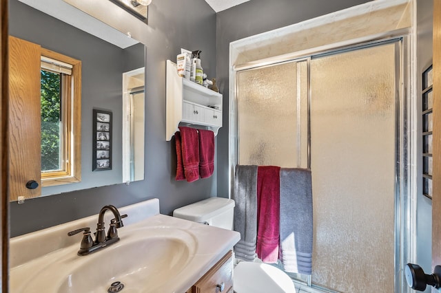 bathroom with walk in shower, vanity, and toilet