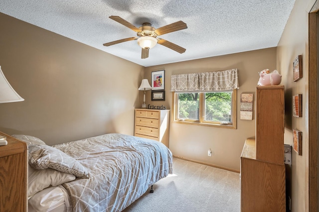 carpeted bedroom with ceiling fan and a textured ceiling