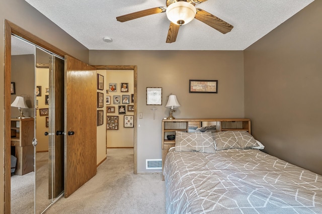 carpeted bedroom with ceiling fan, a textured ceiling, and a closet