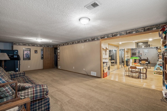 carpeted living room featuring a textured ceiling