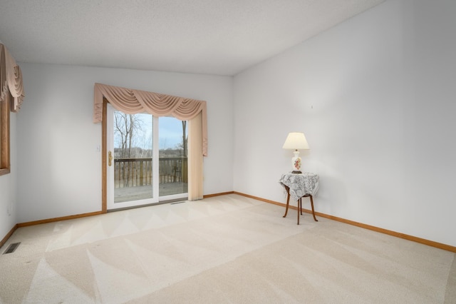 spare room featuring light colored carpet and vaulted ceiling