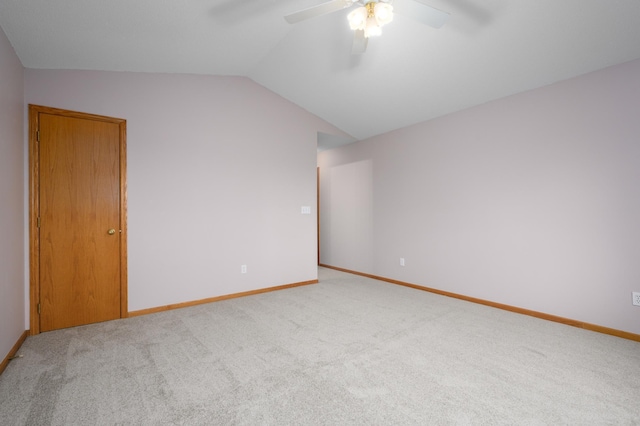 carpeted empty room featuring ceiling fan and vaulted ceiling