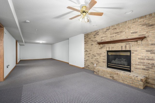 interior space featuring a textured ceiling, ceiling fan, dark carpet, and a fireplace