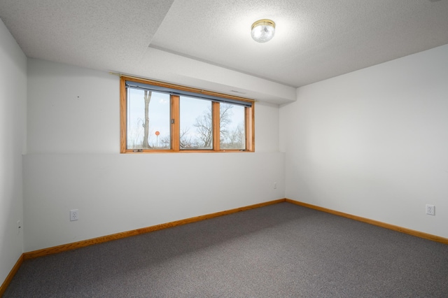 unfurnished room with carpet and a textured ceiling